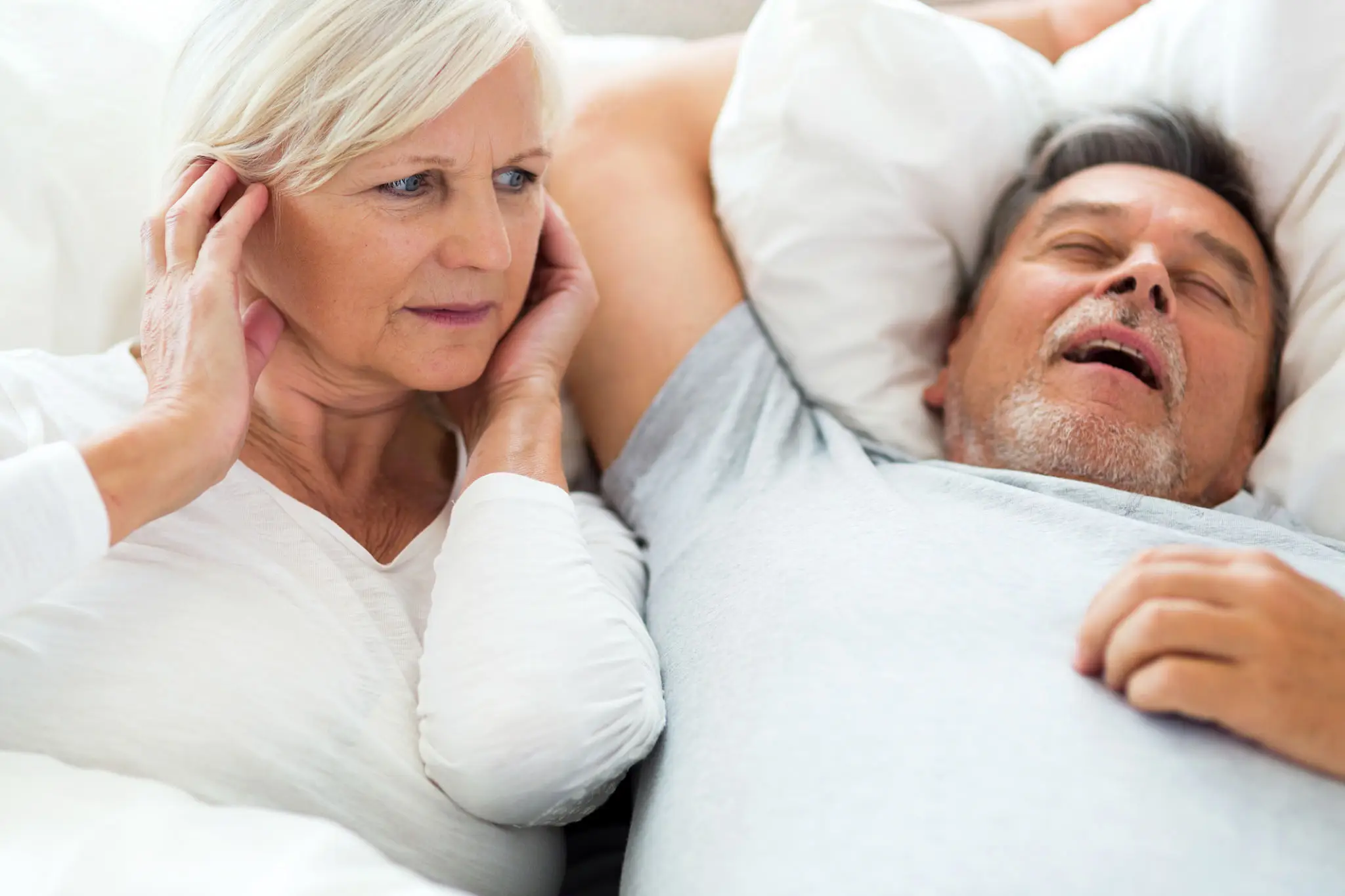 A woman and man laying in bed next to each other.
