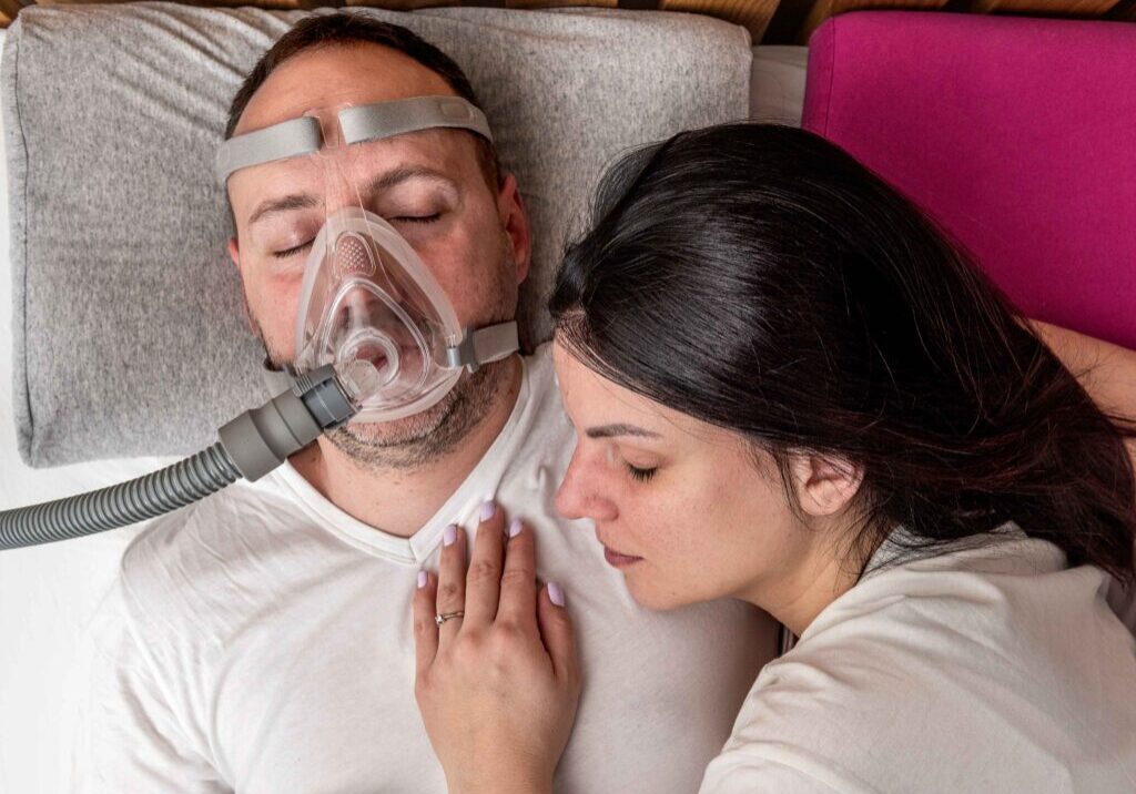 A man and woman laying in bed with their head on the pillow.